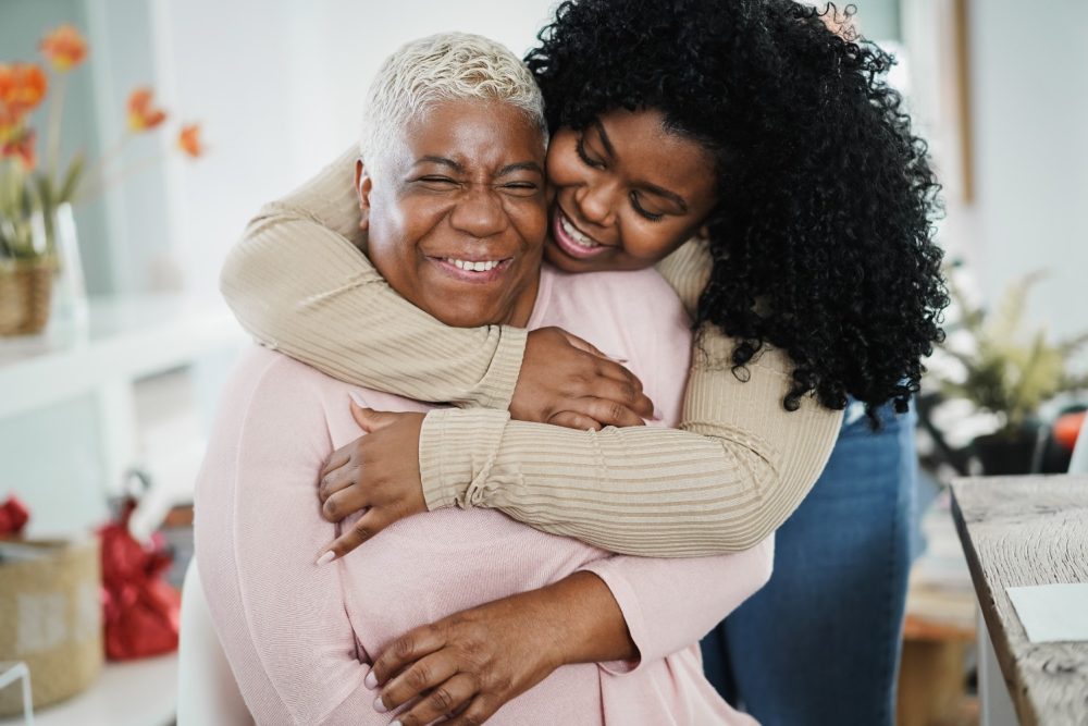 african-daughter-hugging-her-mum-indoors-home-main-focus-senior-woman-face