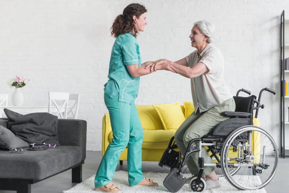nurse-holding-disabled-senior-woman-s-hand-sitting-wheel-chair - Copy